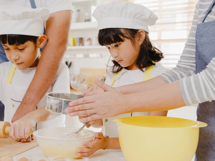 Children slicing a pizza they have made themselves